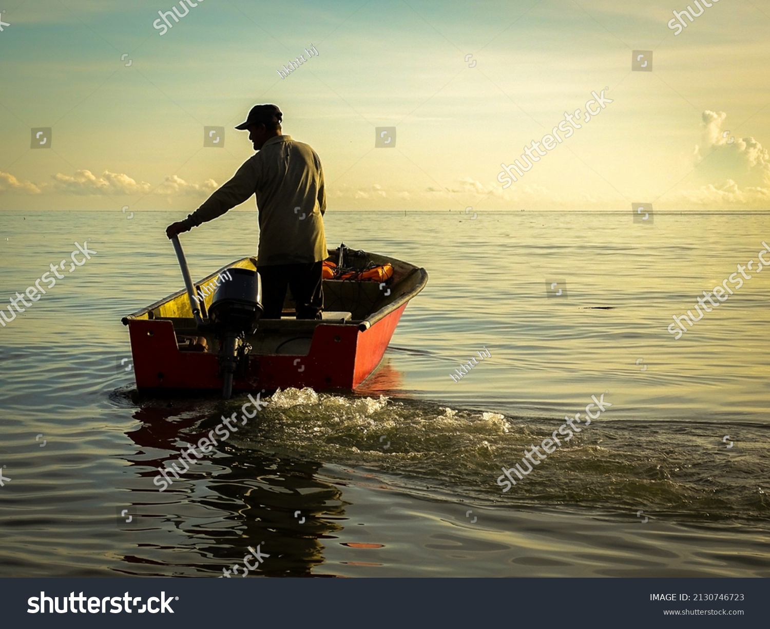 Silhouette of a fishermen on boat with outboard motor boat ready to fishing during beautiful sunrise at Labuan island, Malaysia. #2130746723
