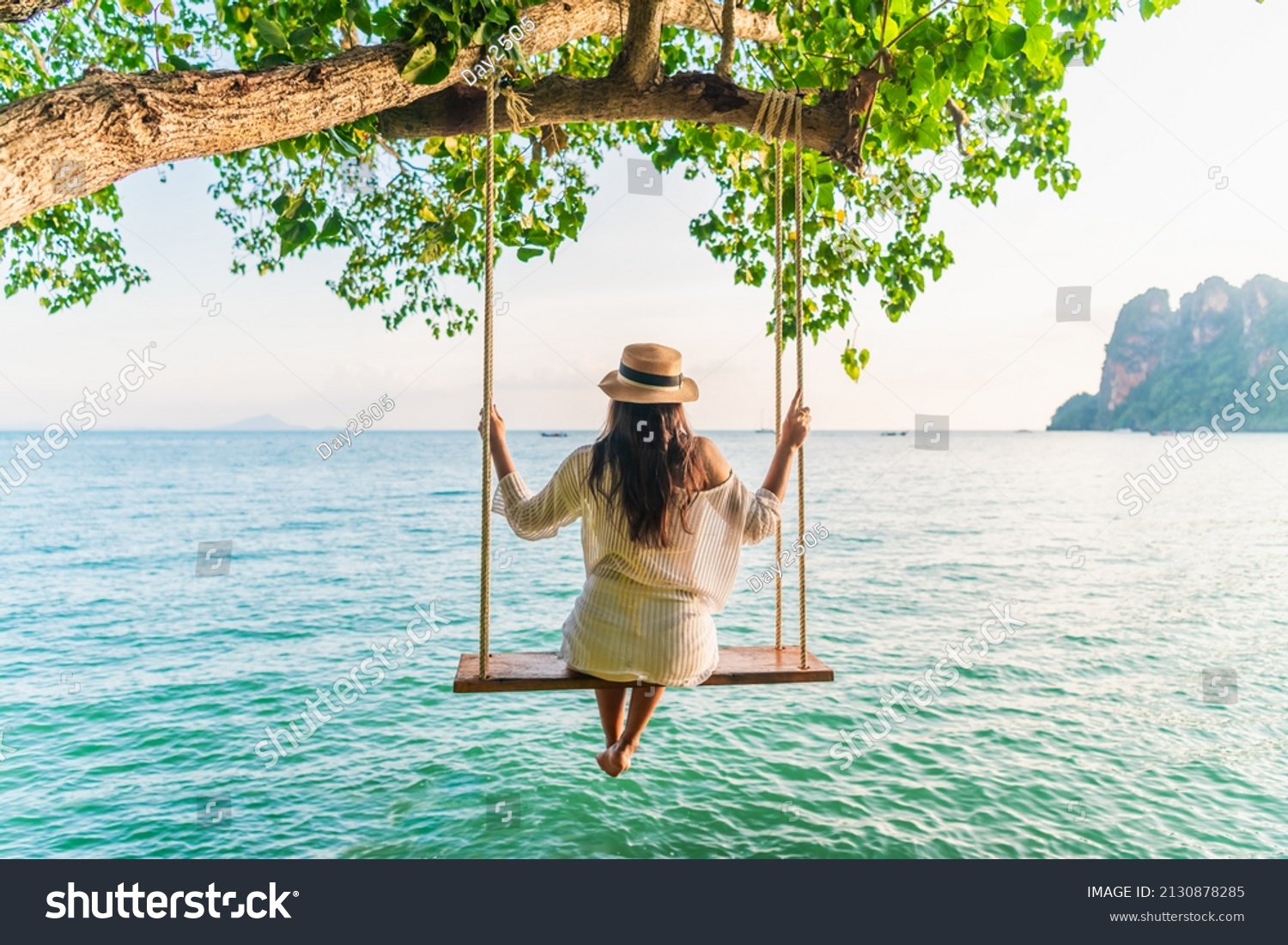 Traveler woman relaxing on swing above Andaman sea Railay beach Krabi, Leisure tourist travel Phuket Thailand summer holiday vacation trip, Beautiful destinations place Asia, Happy dream concept #2130878285