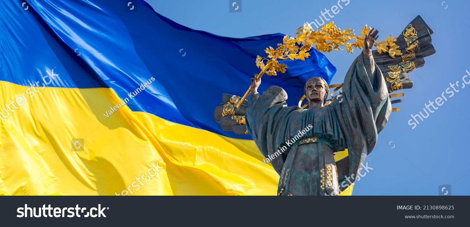 Monument of Independence of Ukraine in front of the Ukrainian flag. The monument is located in the center of Kiev on Independence Square. Russian war in Ukraine. Stop War. #2130898625
