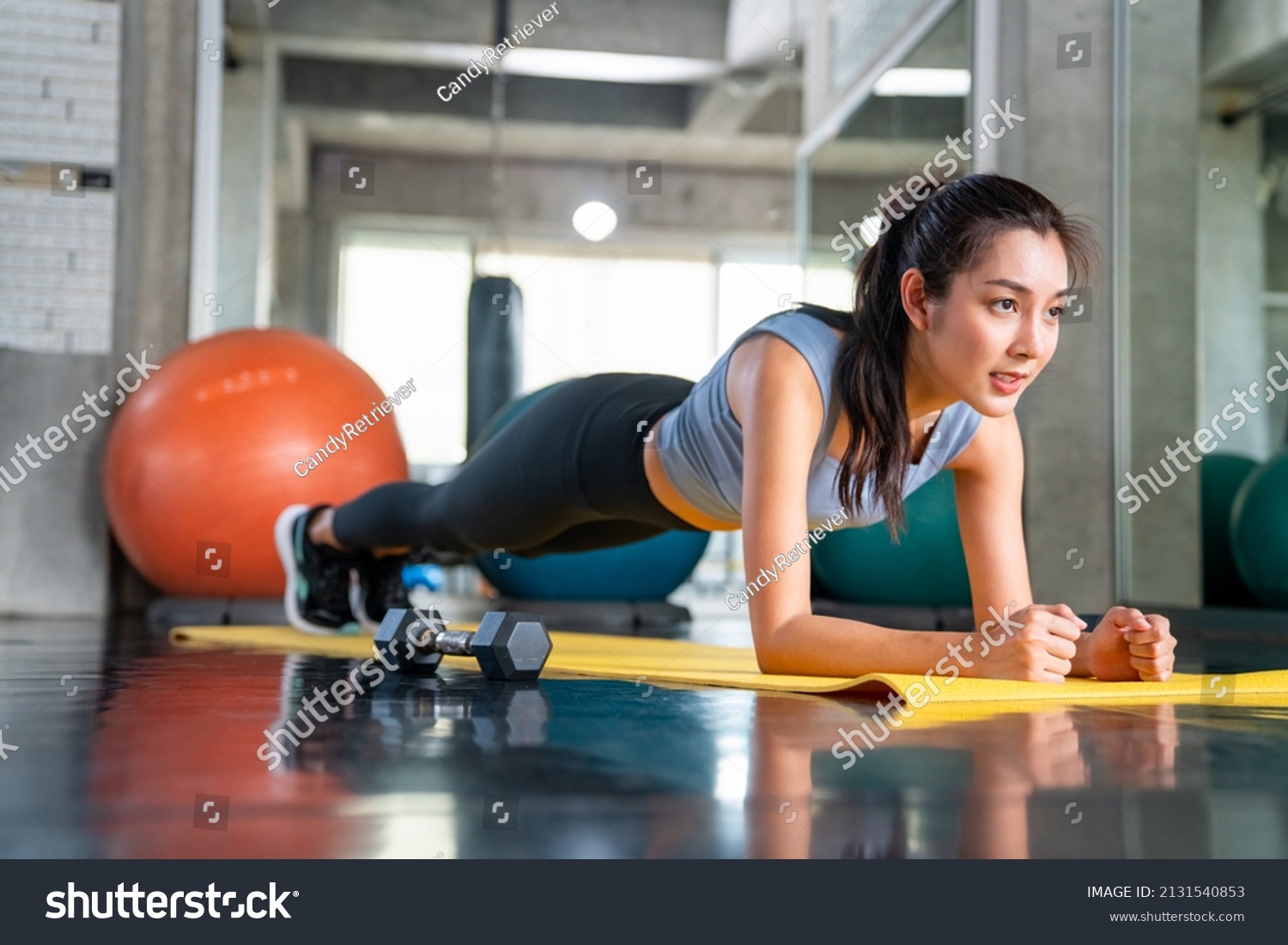Healthy Asian athlete woman in sportswear do plank workout exercise body weight lifting at fitness gym. Strong female body building muscle weight training at sport club. Health care motivation concept #2131540853