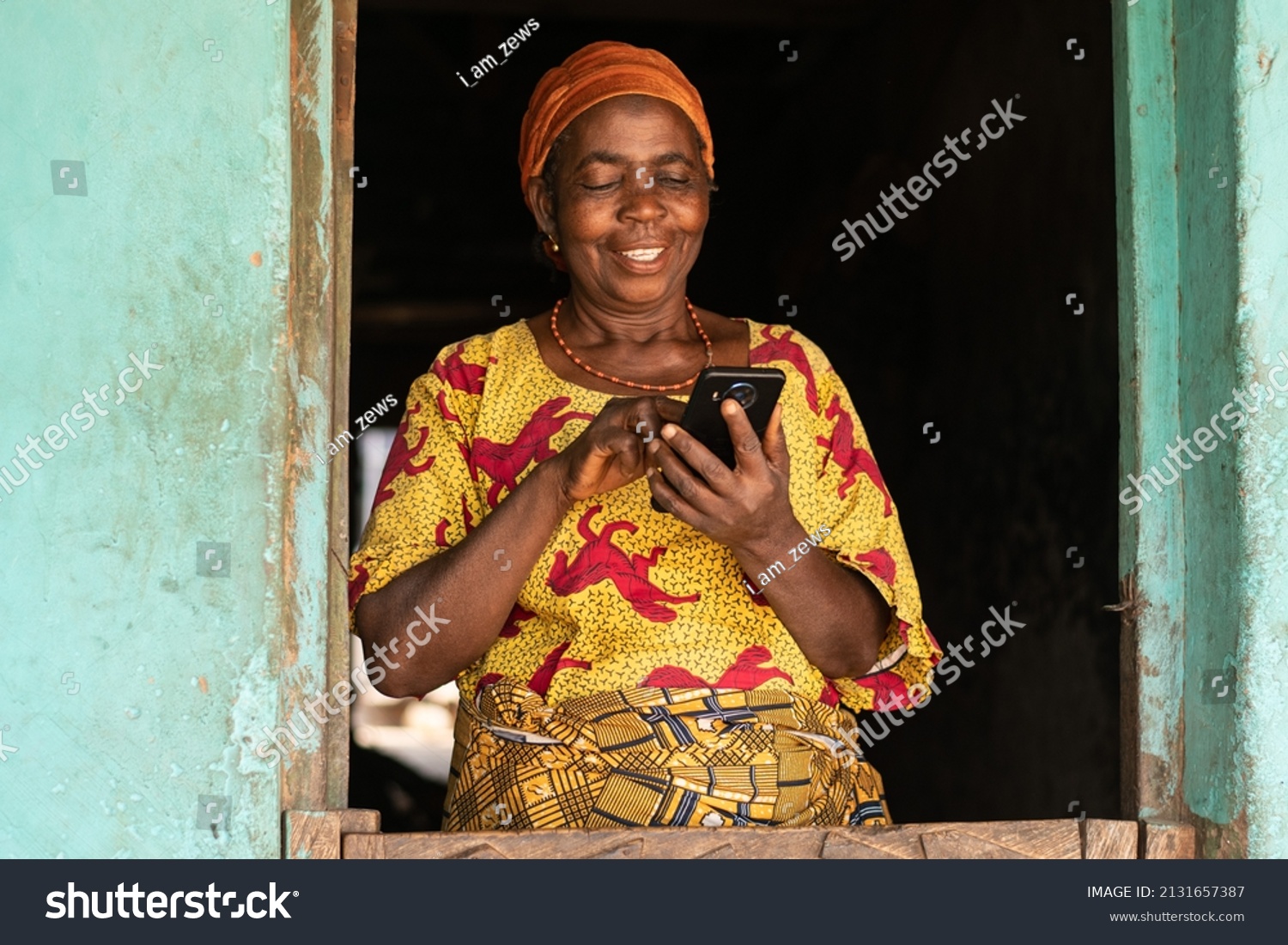 smiling elderly african woman using her phone #2131657387