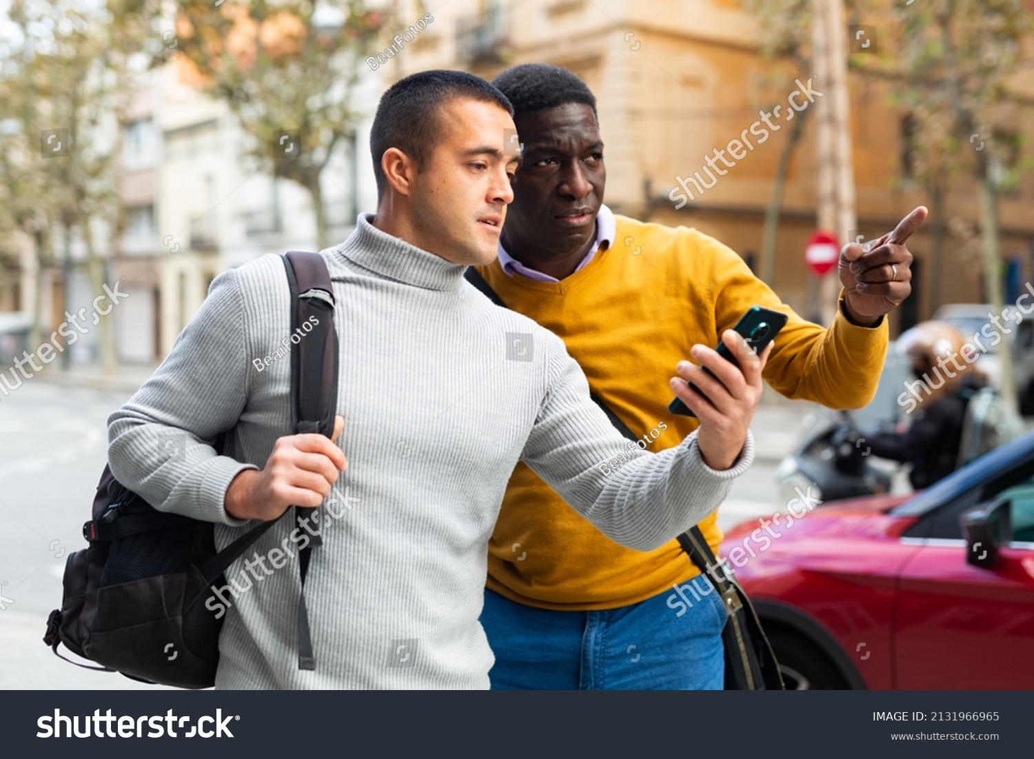 European man with smartphone having conversation with African-american man about directions. #2131966965