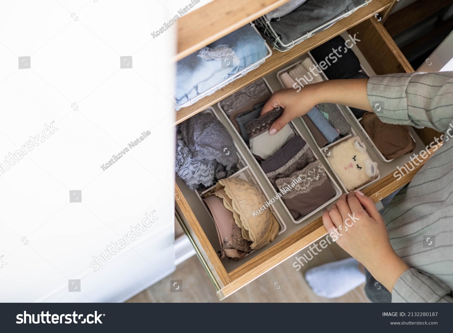Top view female hands comfortable boxes storage for panties, socks, bras Konmari method storage. Woman neatly putting underwear into organizer container for vertical system cupboard general cleaning #2132280187