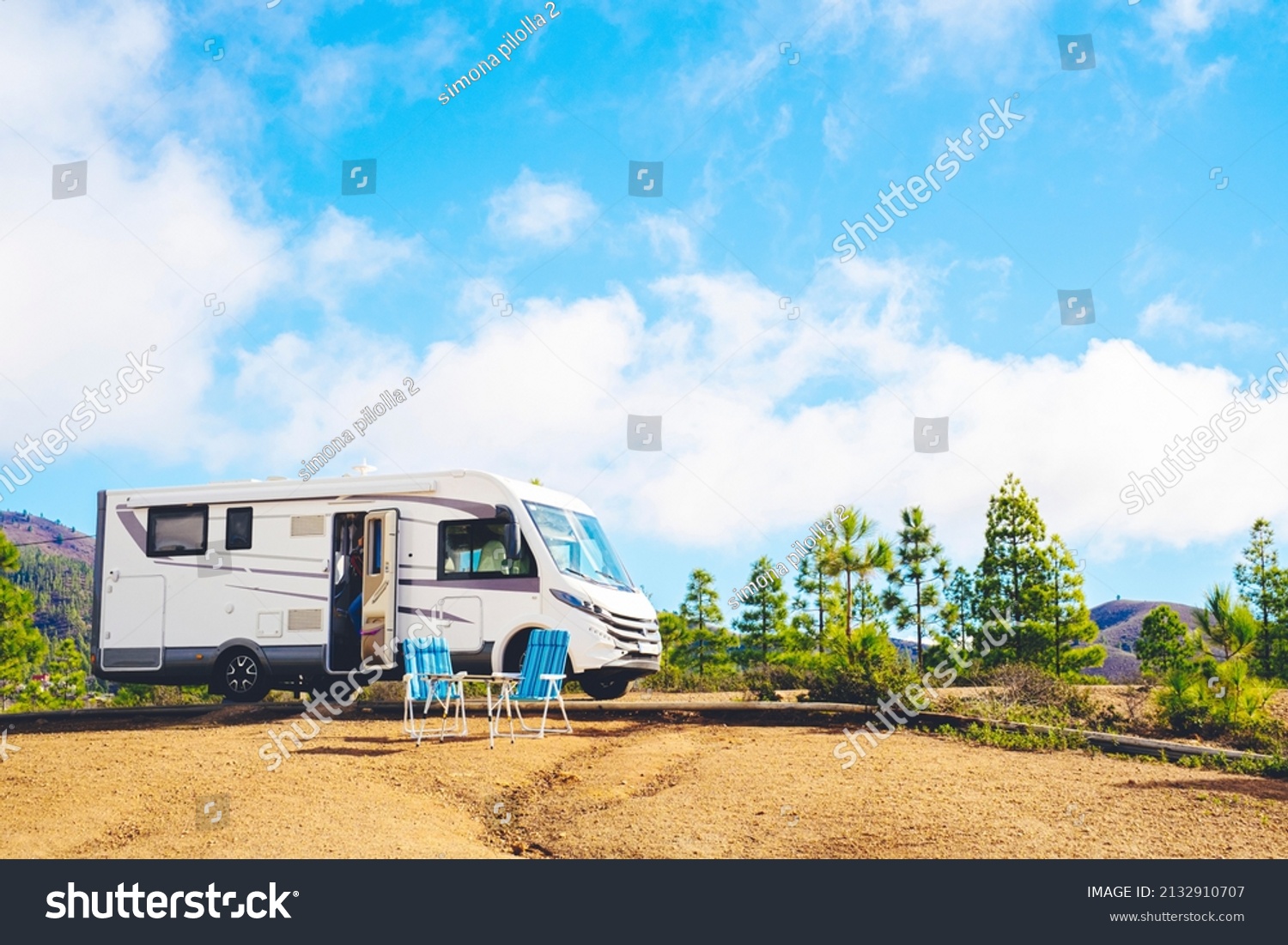 Beautiful tourism camper van campsite in the nature. Travel and rv renting vehicle vacation. Vanlife and wanderlust concept with modern motorhome parked in the nature with blue sky background #2132910707