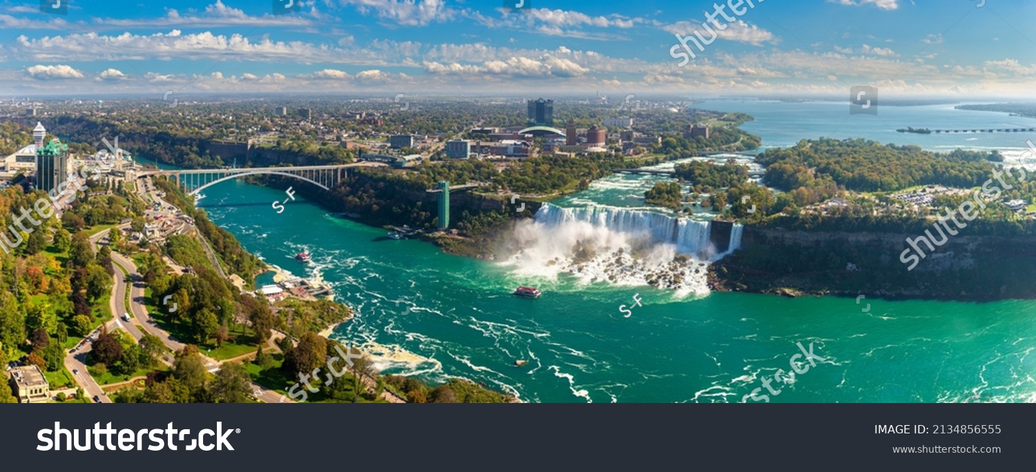 Panorama of aerial view of Canadian side view of Niagara Falls, American Falls and Rainbow International Bridge in Niagara Falls, Ontario, Canada #2134856555