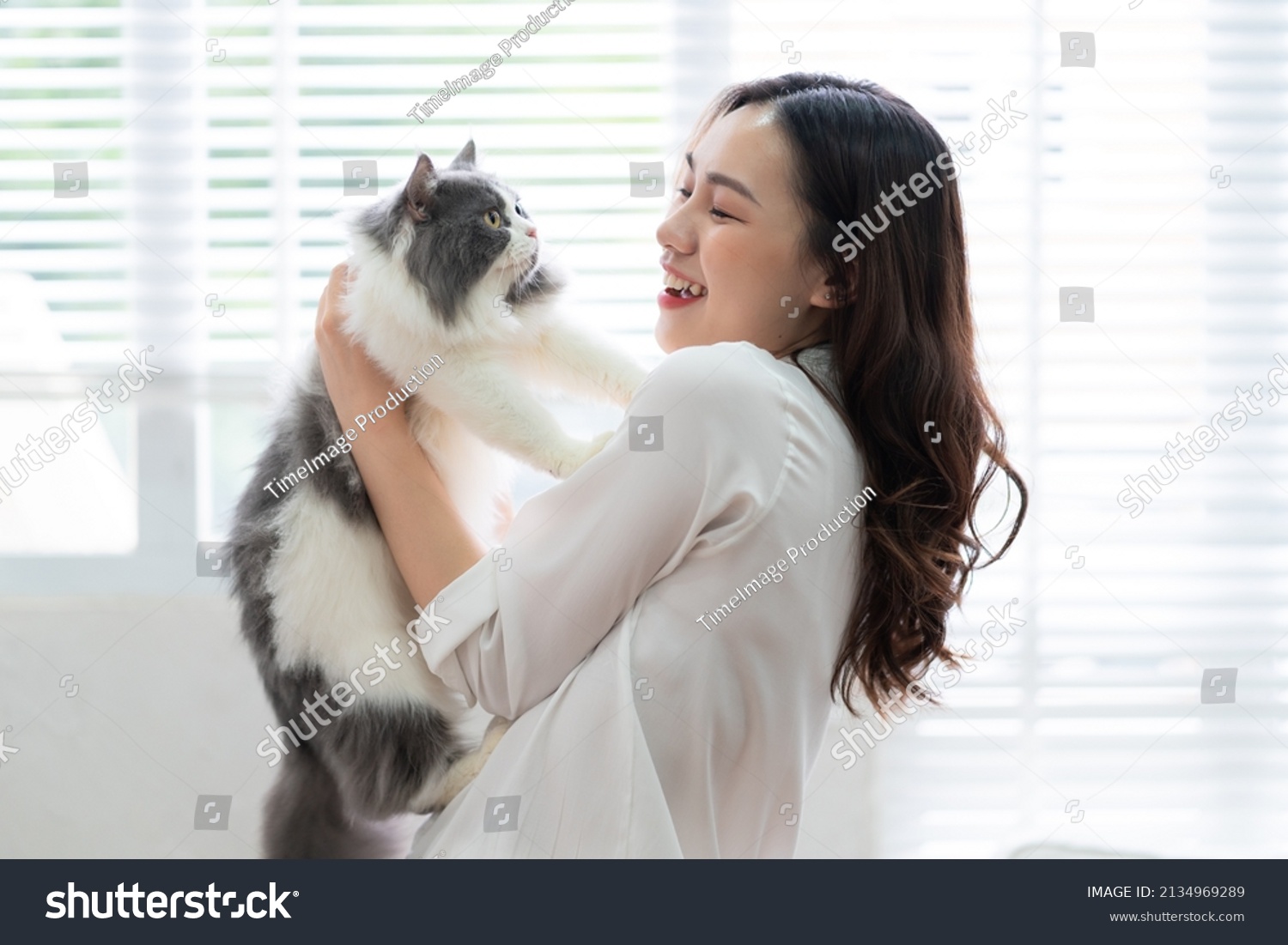 Young Asian woman playing with cat at home #2134969289