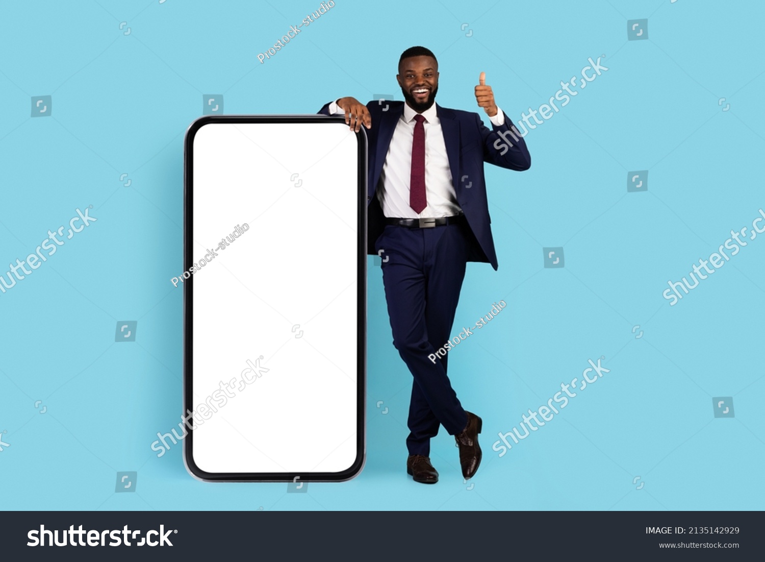 Business App. Cheerful African American Businessman Standing Near Big Blank Smartphone And Showing Thumb Up, Happy Black Male In Suit Demonstrating Copy Space For Online Advertisement, Mockup #2135142929