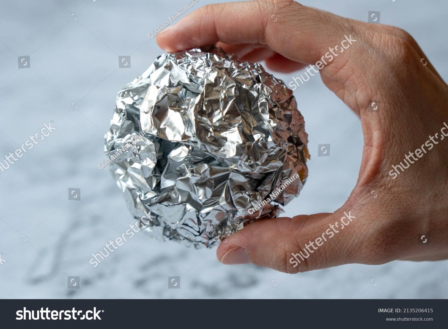 Wrinkled ball of aluminium foil, a material often used in the kitchen. #2135206415