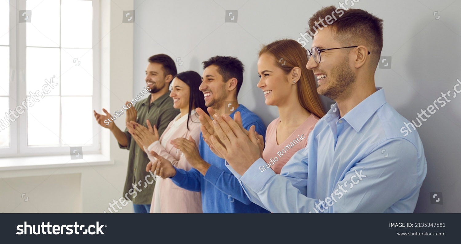 Banner narrow shot of overjoyed diverse businesspeople applaud show appreciation and acknowledgement. Smiling employees clap hands greeting or congratulating with promotion. #2135347581