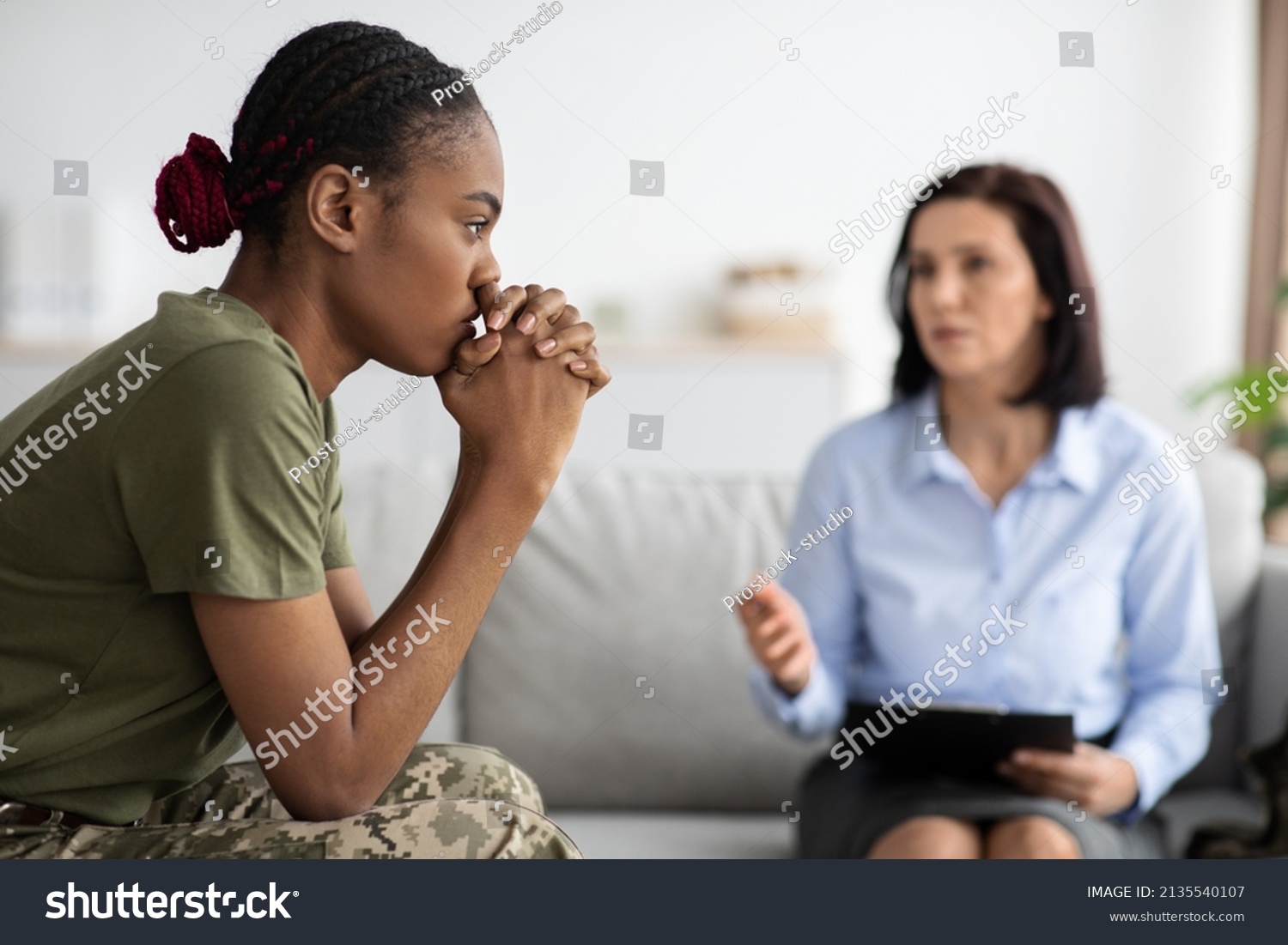 Upset Pensive Black Military Lady Having Therapy Session With Psychologist In Office, African American Soldier Woman Suffering Mental Illness Or Posttraumatic Stress Disorder, Selective Focus #2135540107