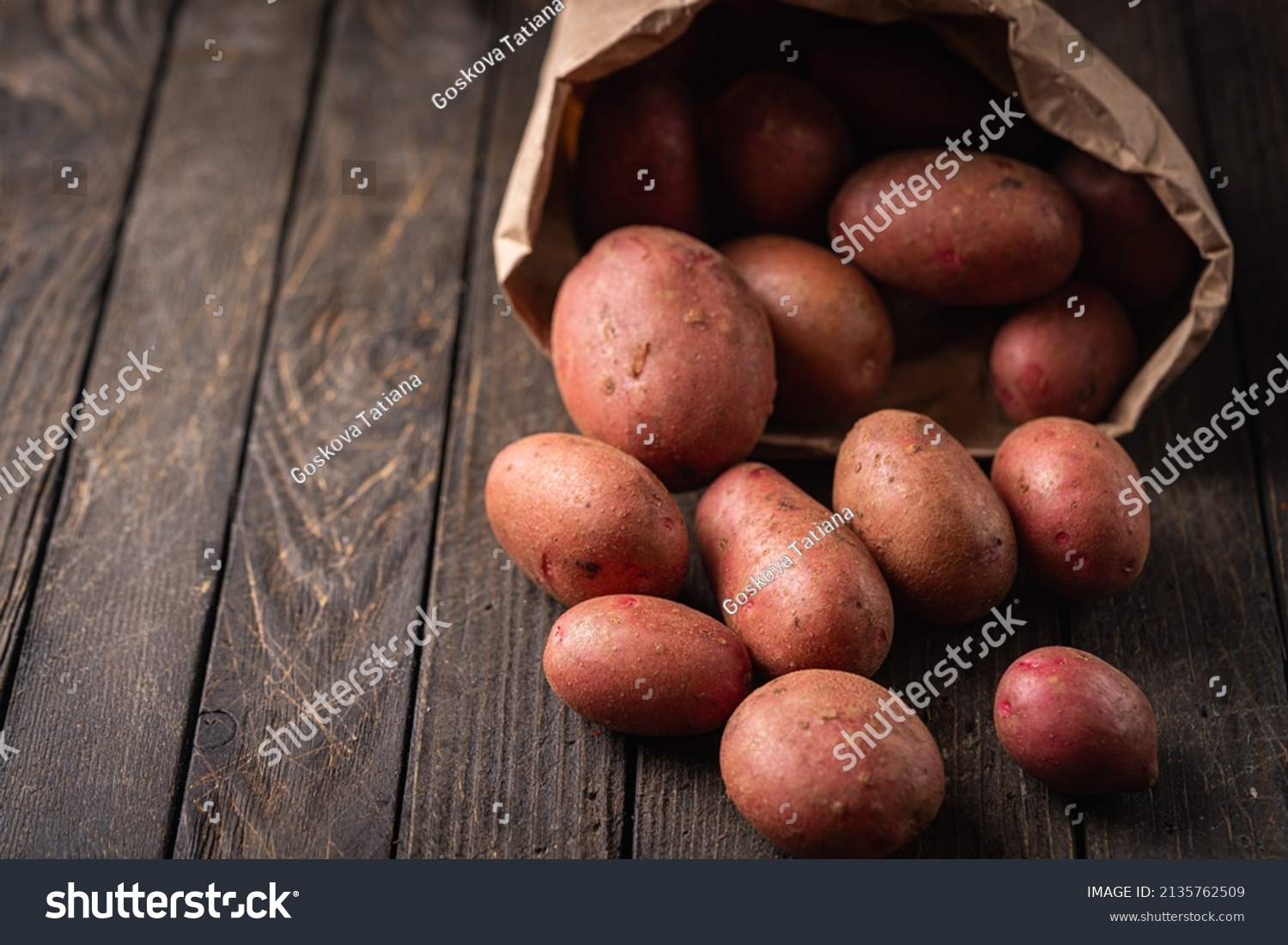 New raw red potatoes in paper bags on wooden background #2135762509