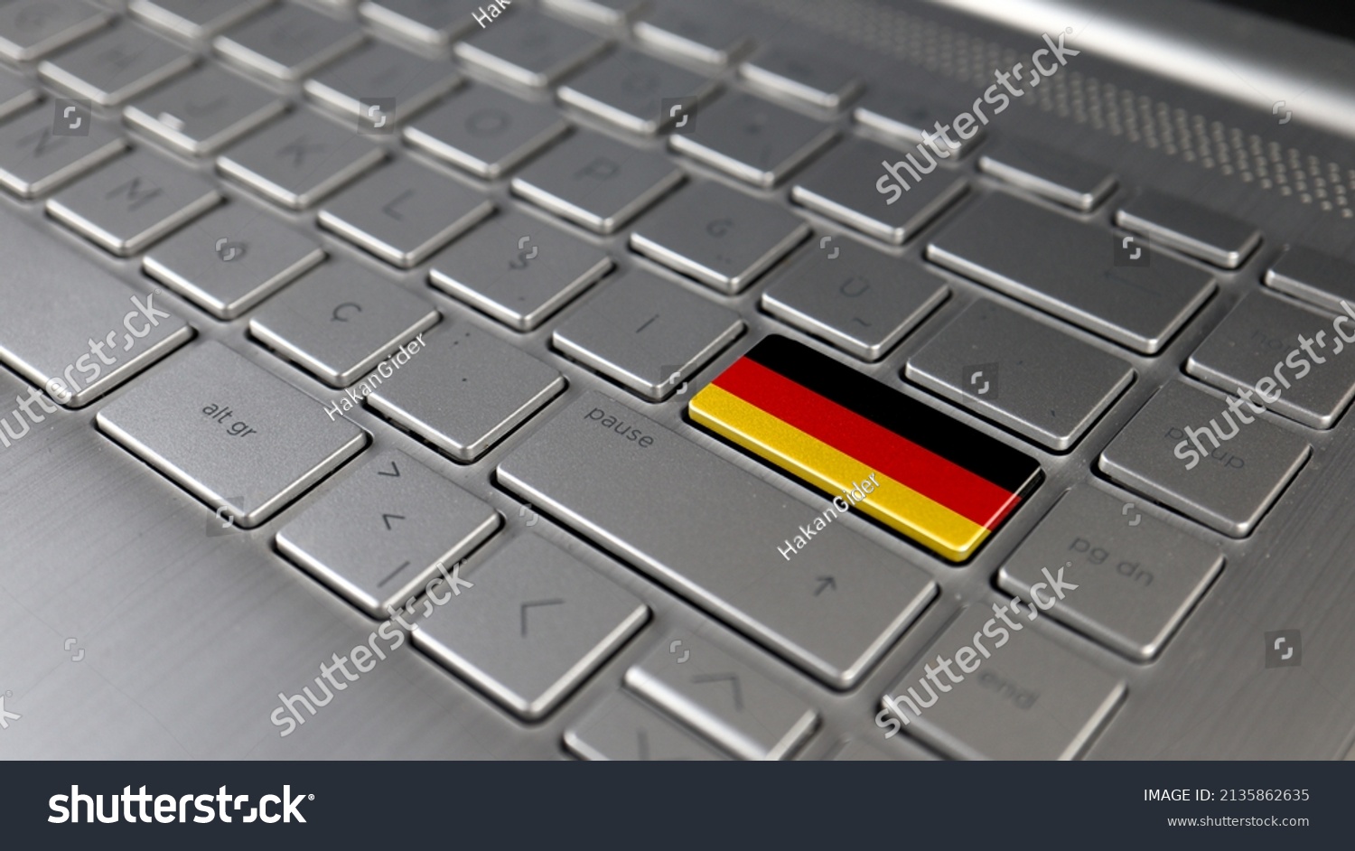 Keyboard with Germany flag on the enter button, represents cyber attack of Germany, metaphor of learning German language, grey keypad close up, front view, selective focus #2135862635