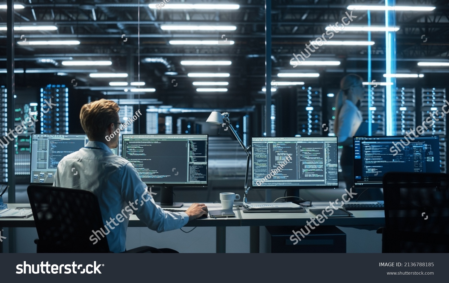 System Administration and Machine Learning Engineer Programming at His Workstation. Man Plans and Carries Out Work to Expand the Network Structure of the Enterprise at His Office #2136788185