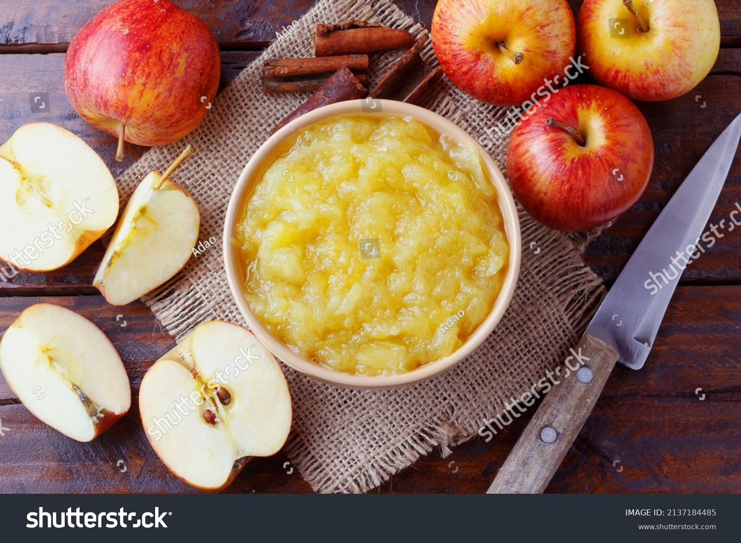 homemade apple sauce or apple puree in ceramic bowl over rustic wooden table. top view #2137184485