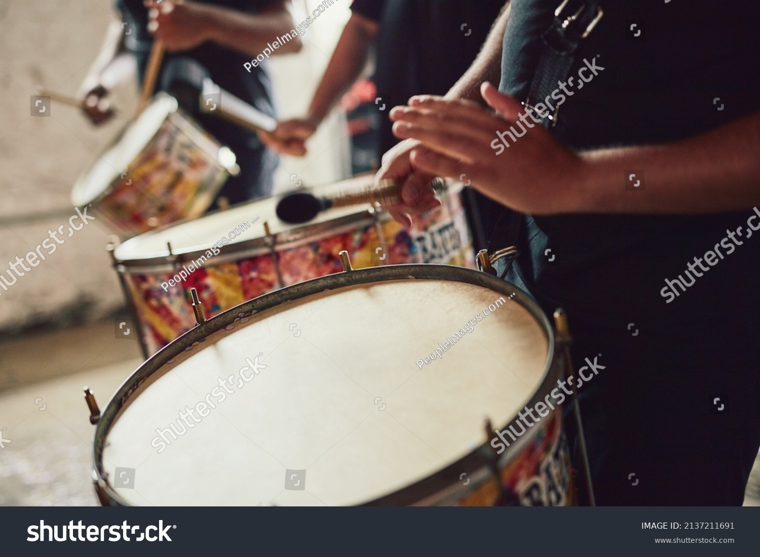 Sounds that come straight out of Brazil. Closeup shot of a musical performer playing drums with his band. #2137211691