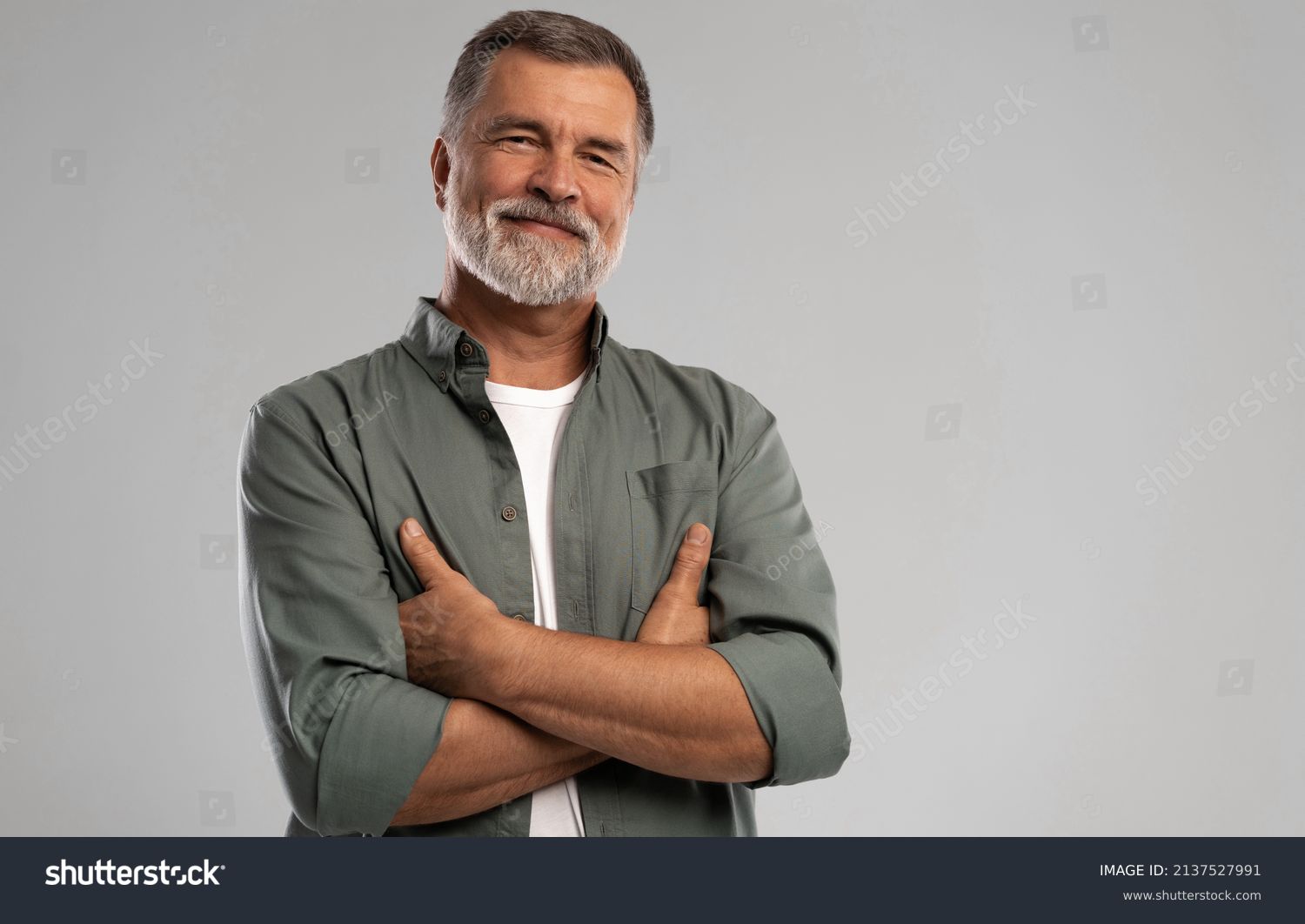 Portrait of smiling mature man standing on white background. #2137527991
