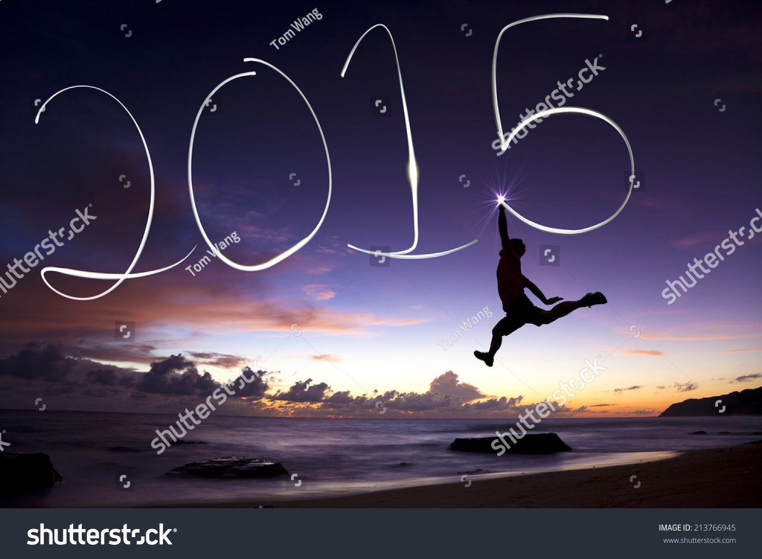 happy new year 2015.young man jumping and drawing 2015 by flashlight #213766945