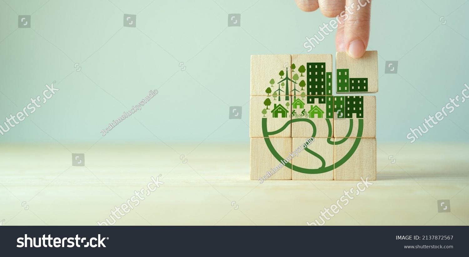 Eco friendly, green company culture concept. Carbon neutral and net zero target. Sustainable enviroment and business. Build green community. Hand holds wooden cubes with eco globe on grey background. #2137872567