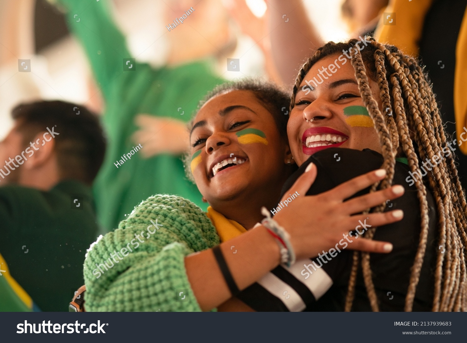 Brazilian young sisters football fans celebrating their team's victory at stadium. #2137939683