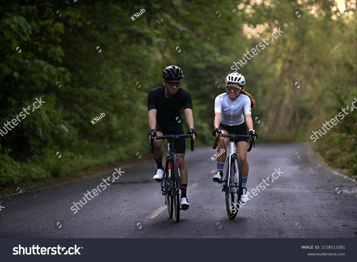 happy couple cycle or ride bicycle on rode in countryside for health life style #2138513281