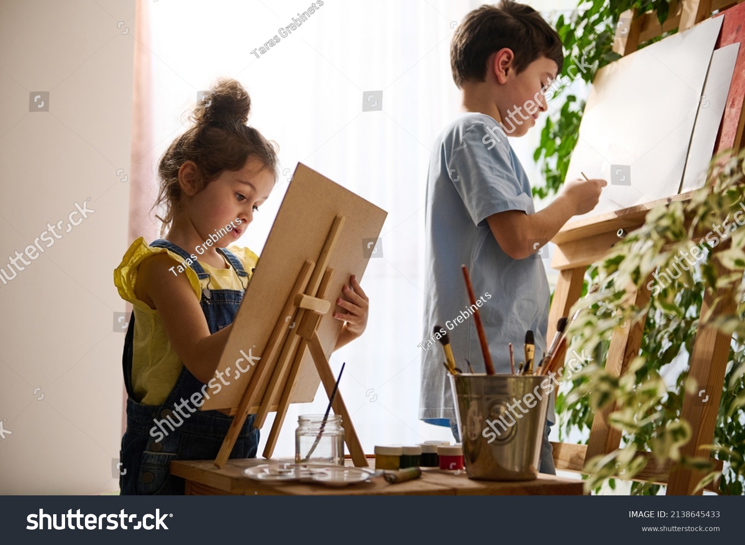 Beautiful smart children, preschool girl schoolboy enjoying art class, drawing, painting images on canvas with oil and watercolor paints. Creativity, education, art, kidsnentertainment, hobby concept #2138645433