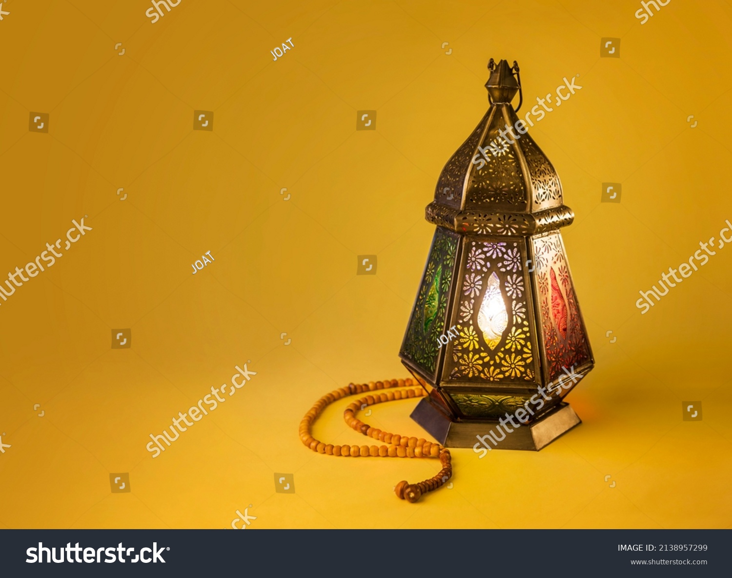 Fawanis. Traditional Ramadan lantern with prayer beads on bright yellow background. Clear space for text. #2138957299