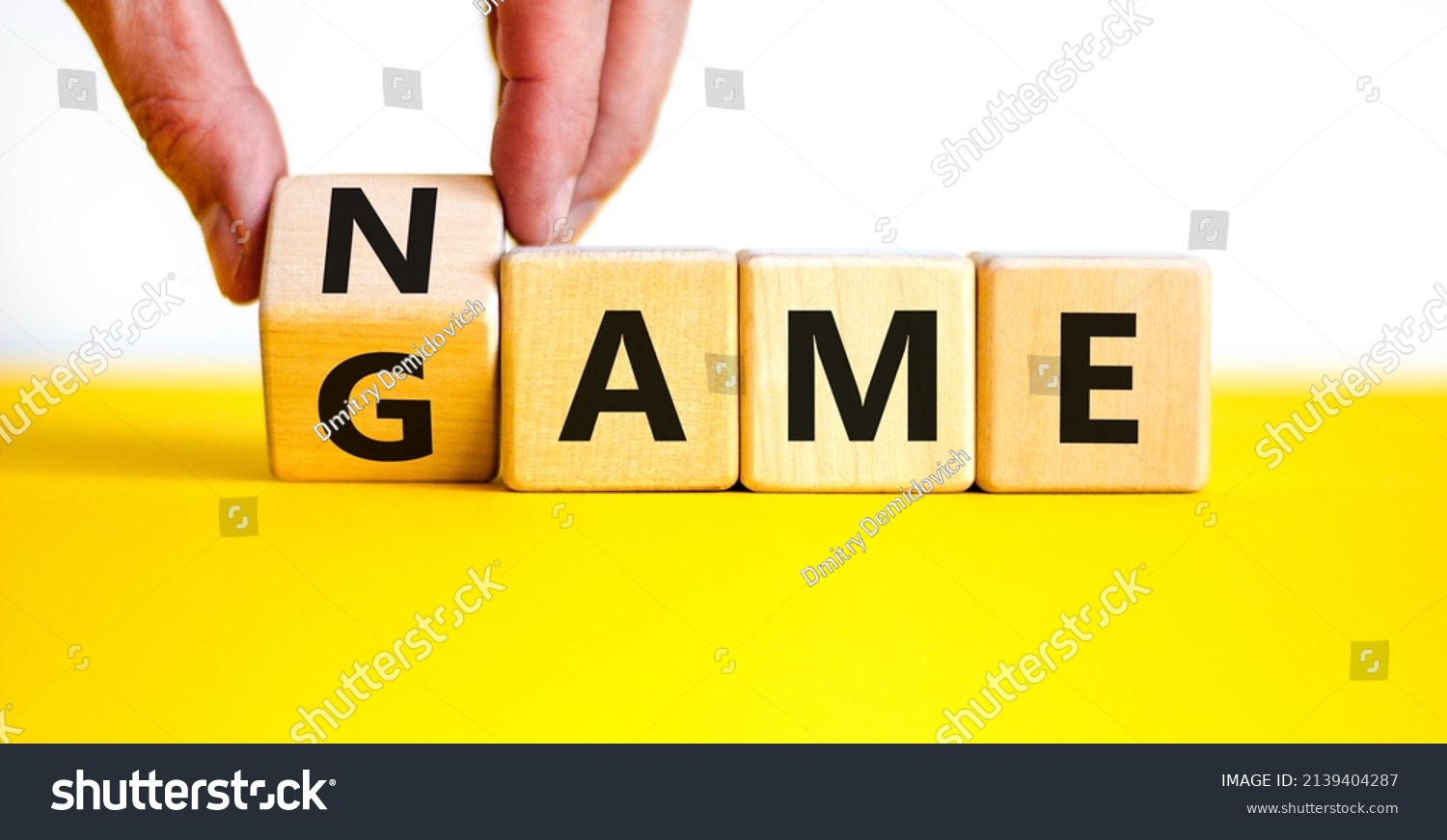 Name of the game symbol. Wooden blocks with concept words Name Game. Businessman hand. Beautiful yellow table white background. Business and name of the game concept. Copy space. #2139404287