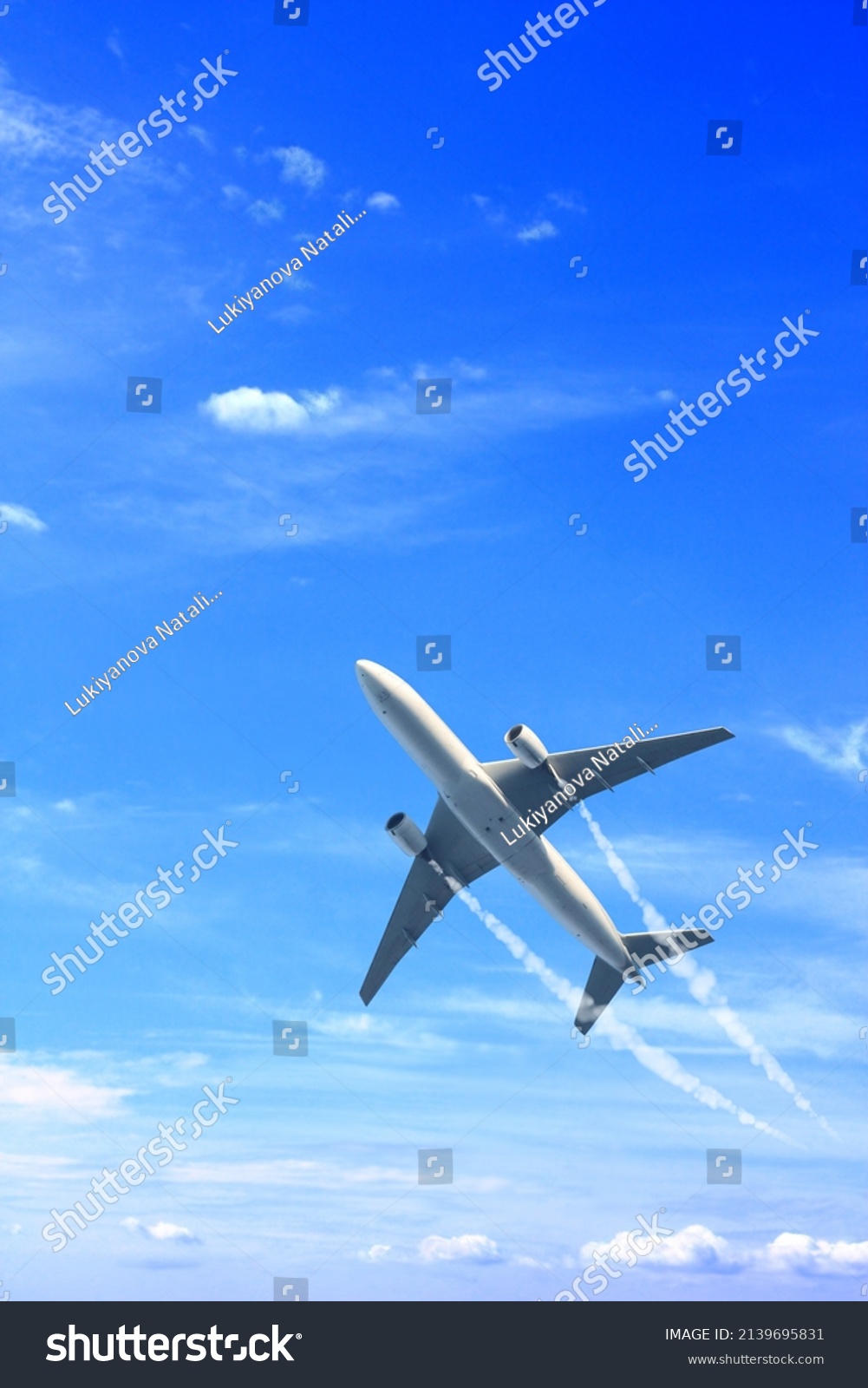 Vertical nature background with aircraft and Jet trailing smoke in the sky. Airplane and condensation trail. Foggy trail jet and plane in blue sky with white clouds. Traveling the world concept #2139695831