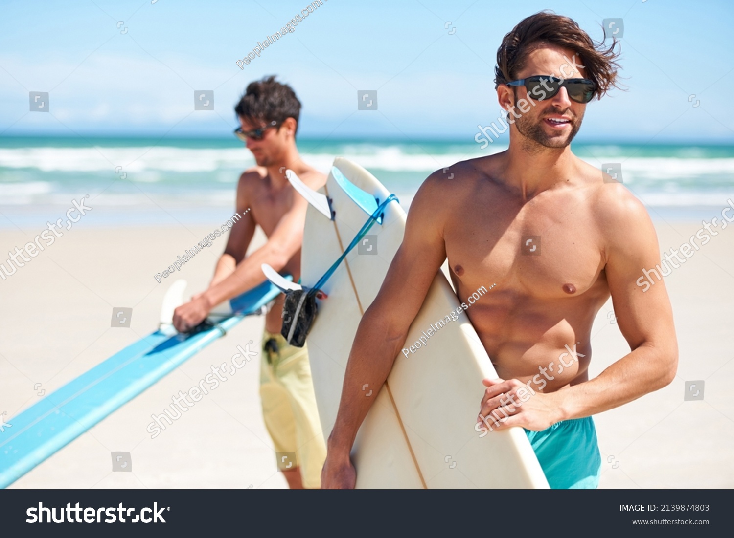Surfs up. Two friends at the beach getting ready to head into the water for a surf. #2139874803
