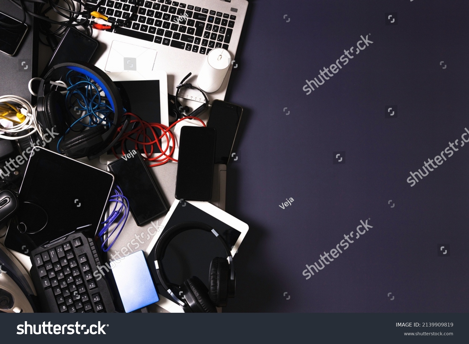 Old computers, digital tablets, mobile phones, many used electronic gadgets devices, broken household and appliances on gray background. Planned obsolescence, electronic waste for recycling concept #2139909819