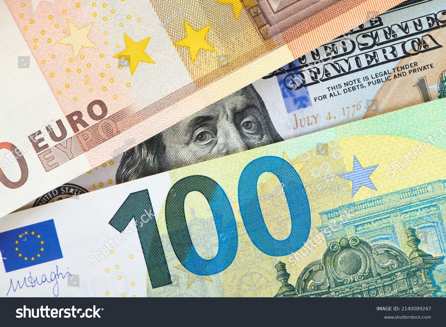 Euro and dollar notes. euro against dollar. A closer look of the president of the USA with a dollar bill, peeping out from behind a euro bill. USA and Europe finance relation. Close up top view. #2140089247