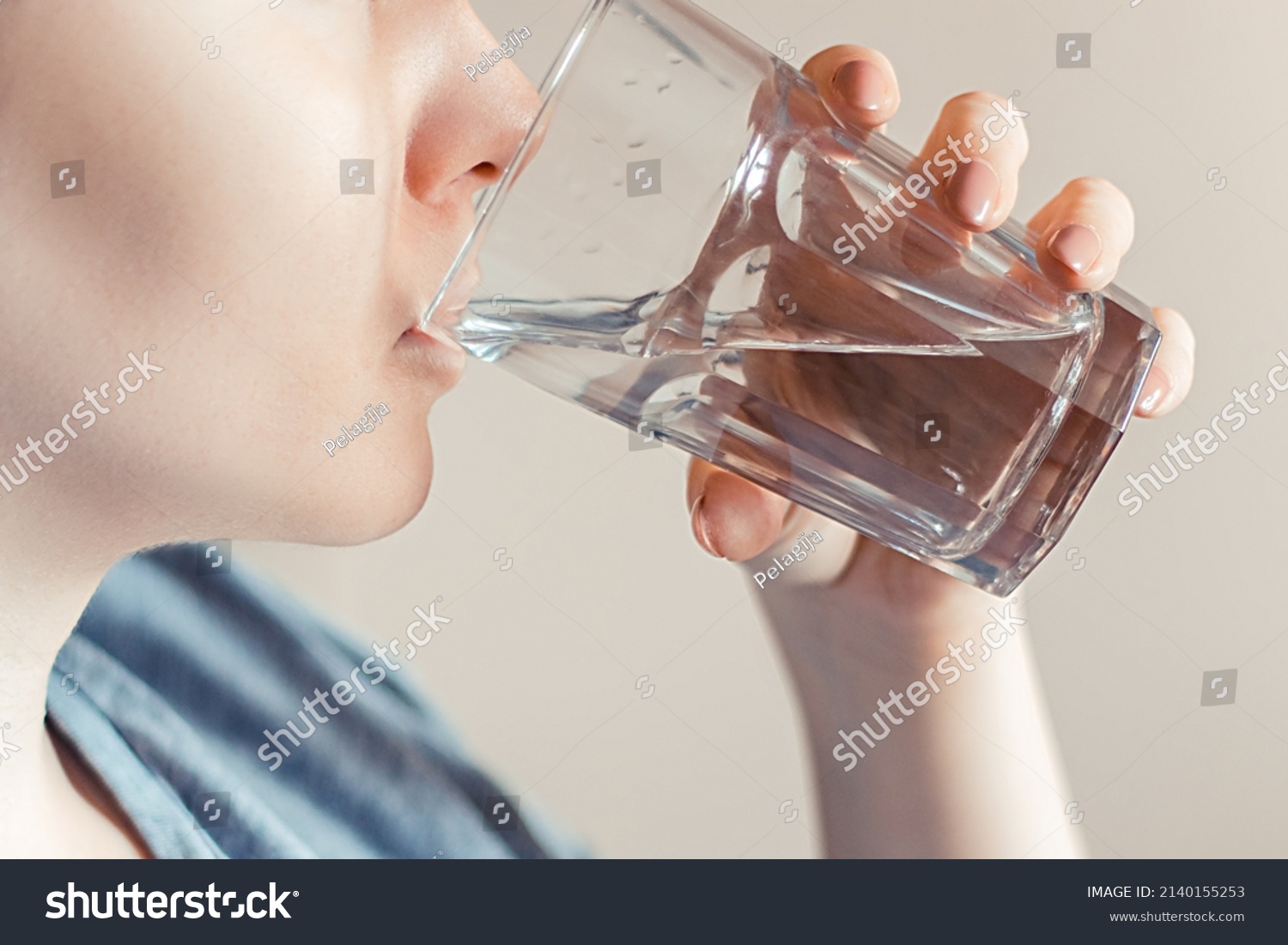 Woman drinks clean water. World Water Day. Health care concept. Diet and detox, increase metabolism. Hand holds drinking glass of water. #2140155253