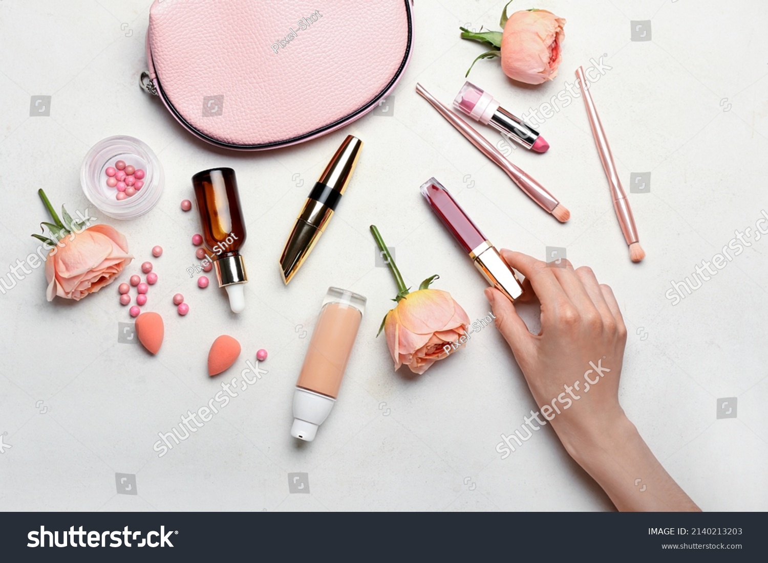 Female hand with decorative cosmetics, bag and rose flowers on light background #2140213203