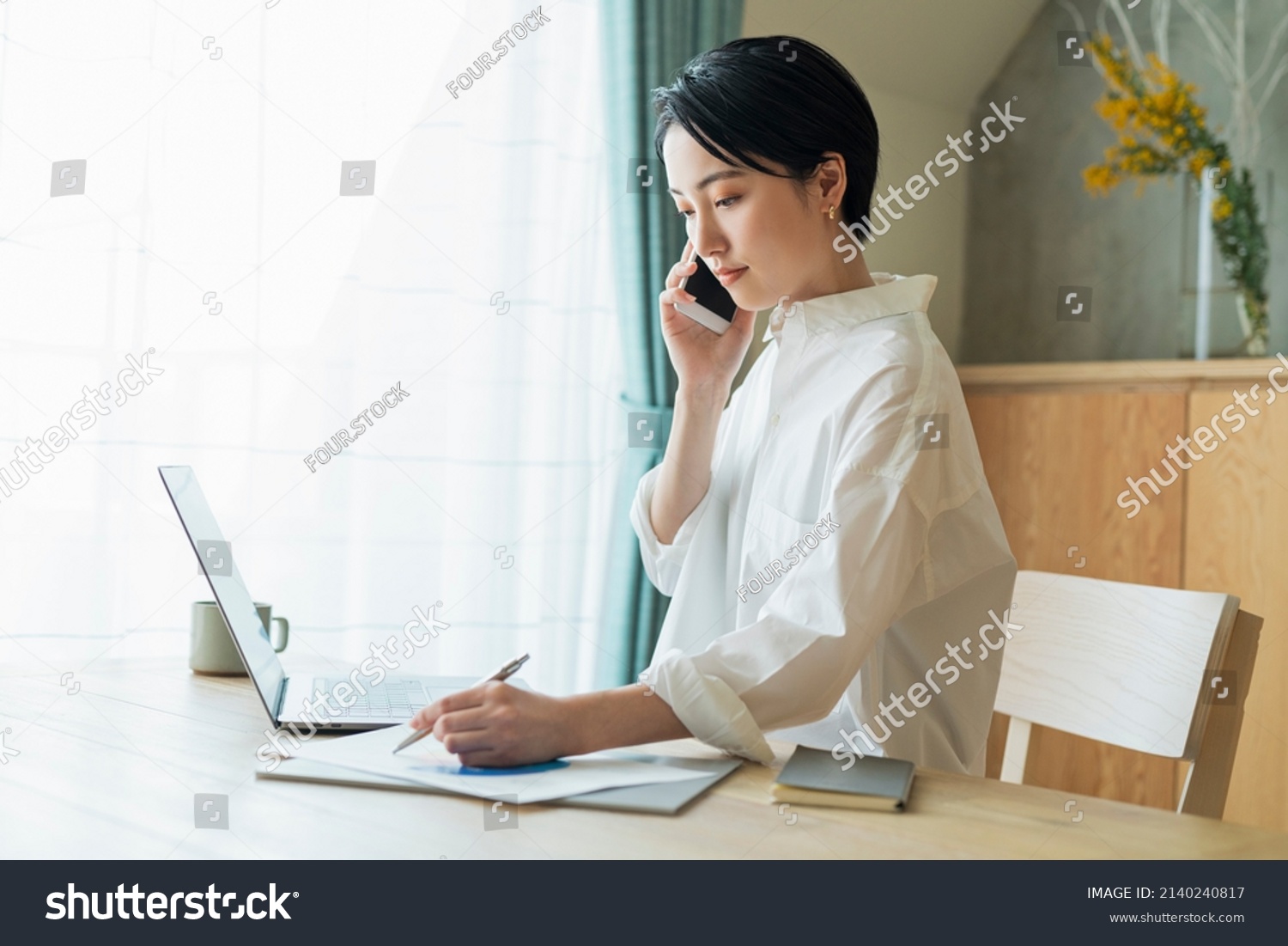 Woman making a phone call while working remotely #2140240817