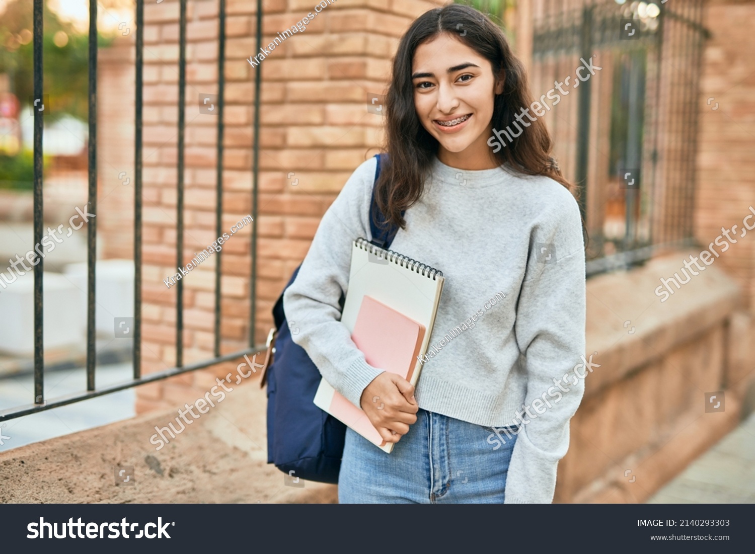 Young middle east student girl smiling happy holding book at the city. #2140293303