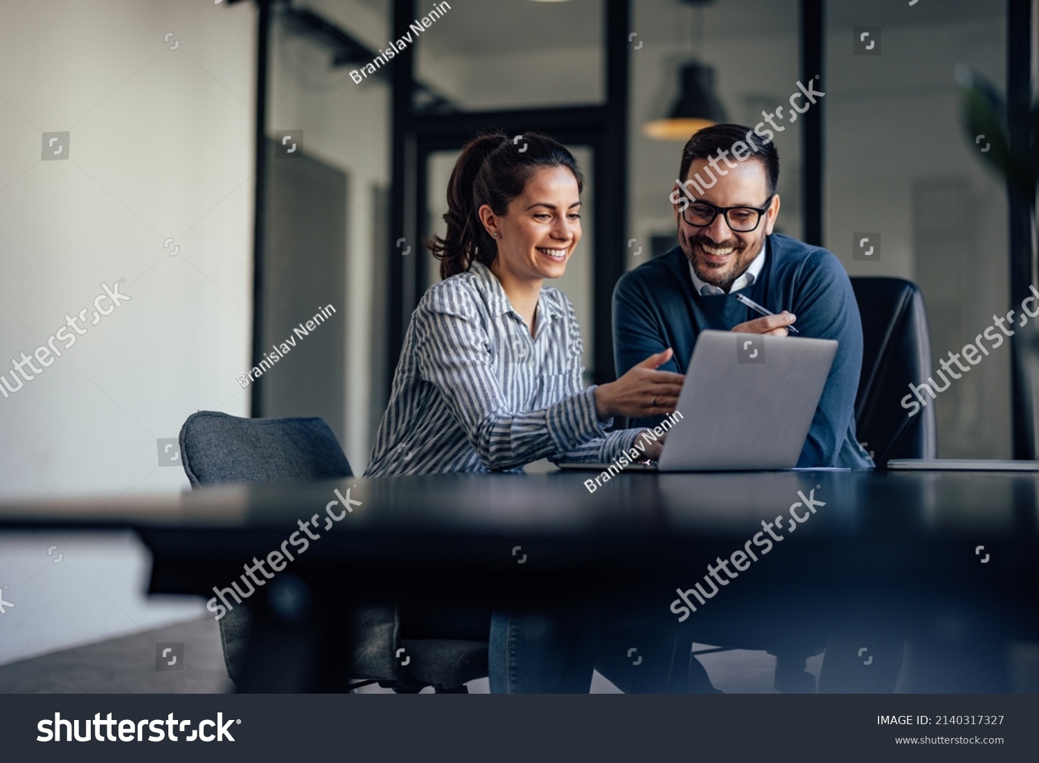 Smiling business people, looking at something over the laptop. #2140317327