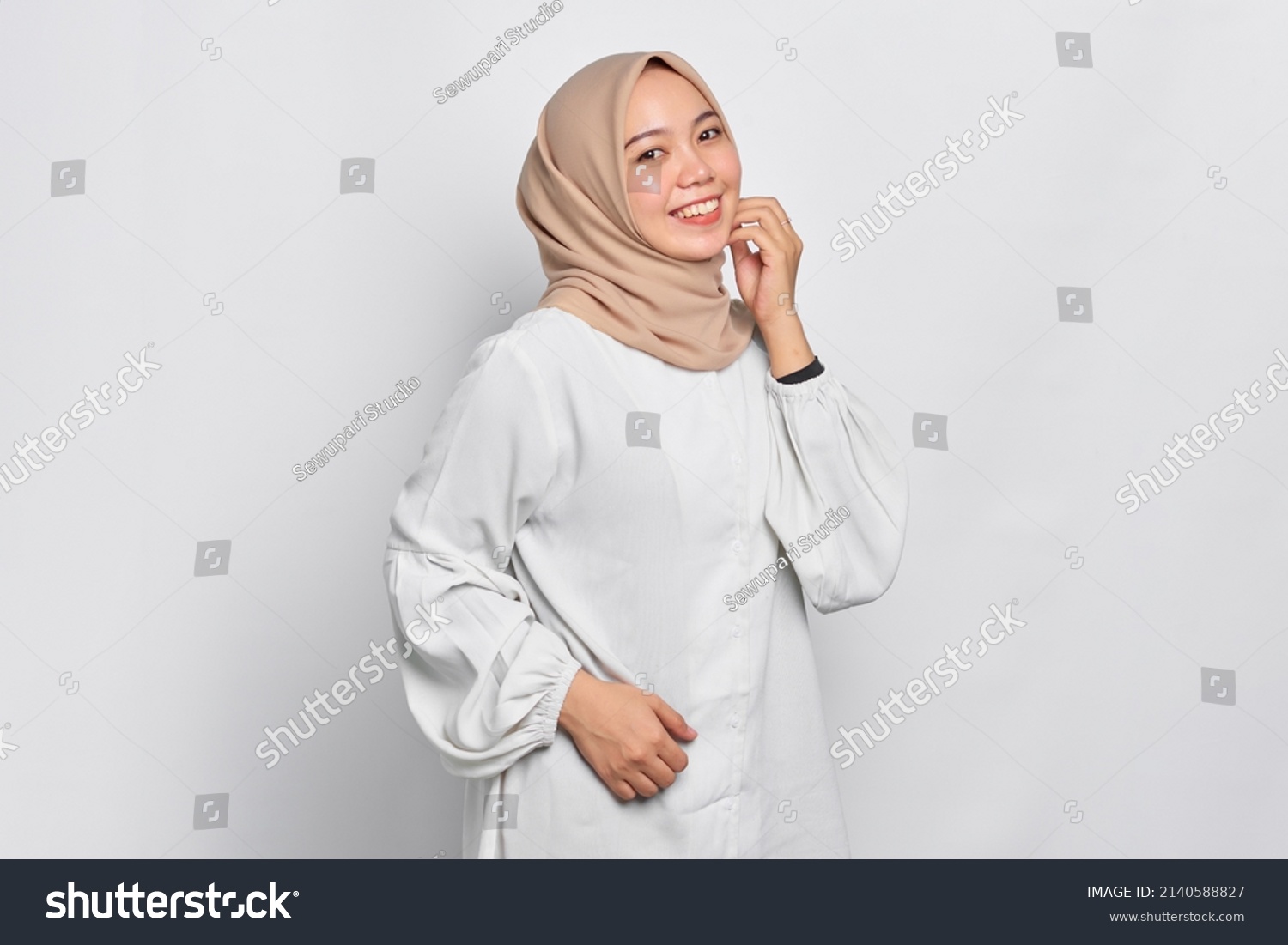 Smiling young Asian Muslim woman feels confident and joyful isolated over white background #2140588827