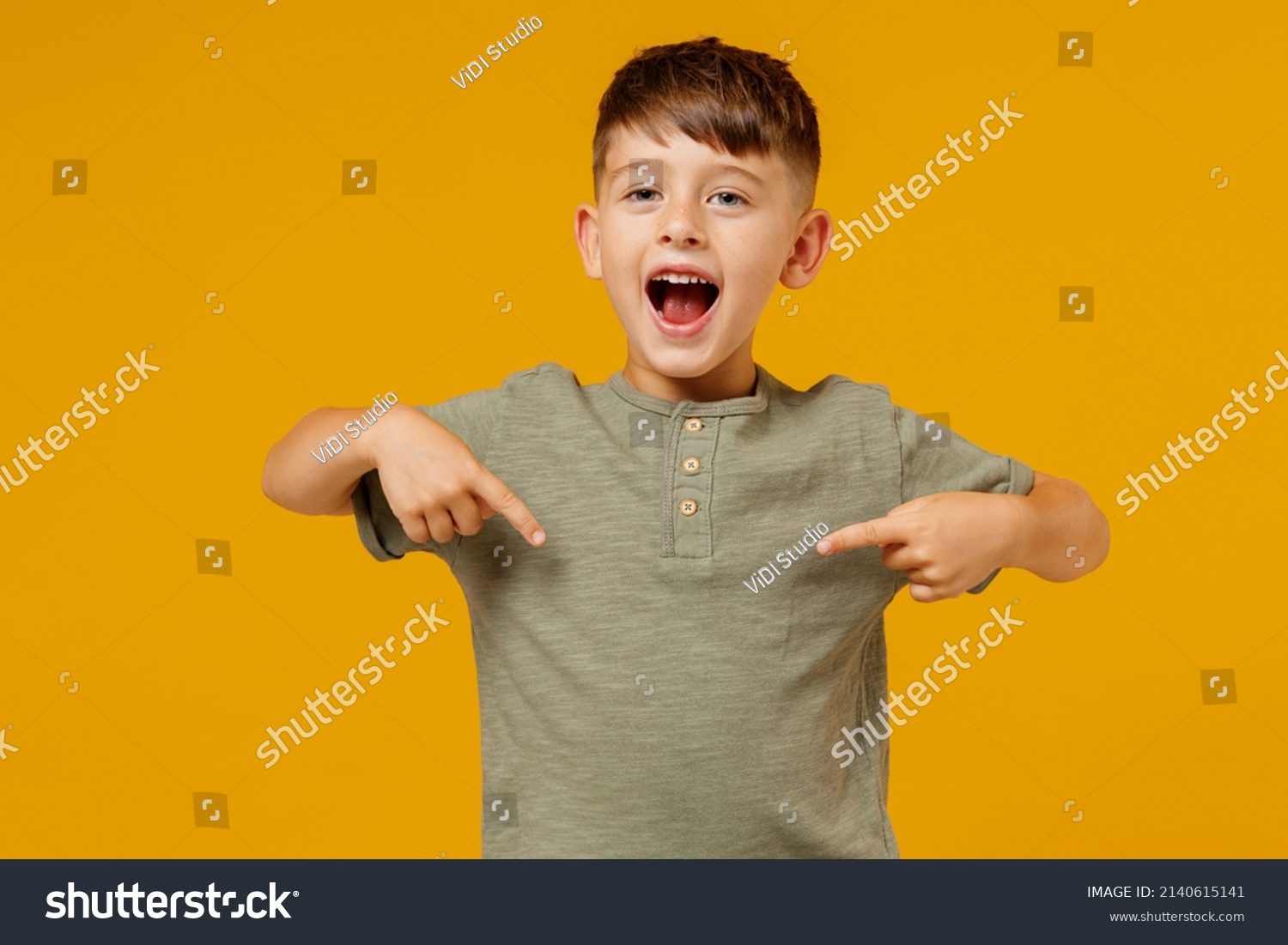 Little small smiling happy boy 6-7 years old in green casual t-shirt point in index finger on himself isolated on plain yellow background studio portrait. Mother's Day love family lifestyle concept #2140615141