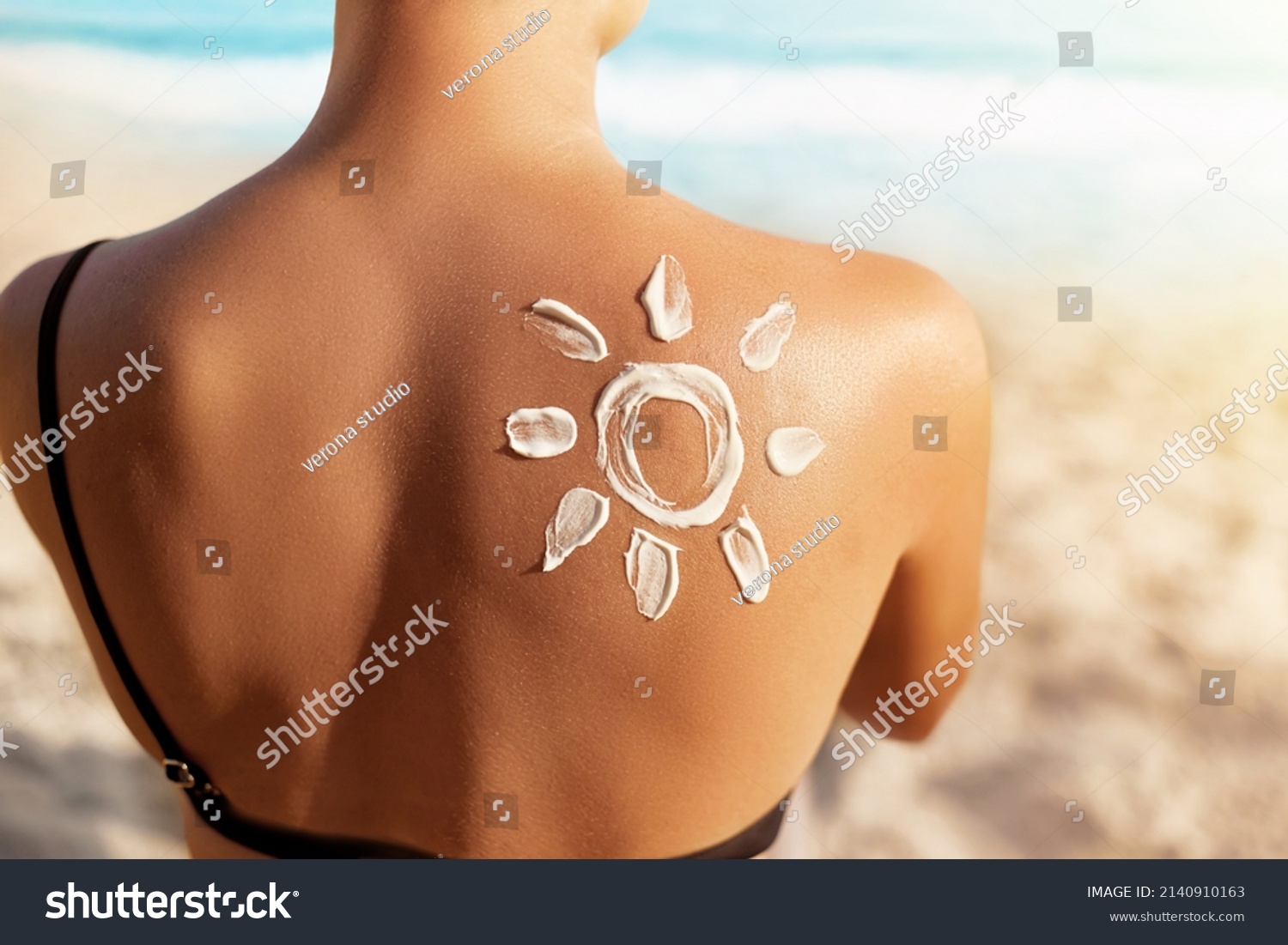 Sun Protection.Sun Cream. Woman Applying Sun Cream on Tanned  Shoulder In Form Of The Sun. Skin and Body Care. Girl Using Sunscreen to Skin.  #2140910163
