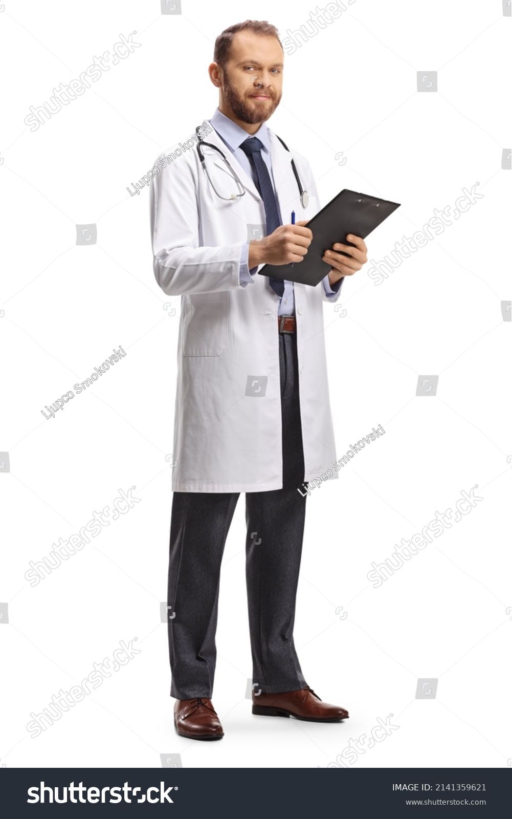Young male doctor holding a clipboard and looking at camera isolated on white background #2141359621