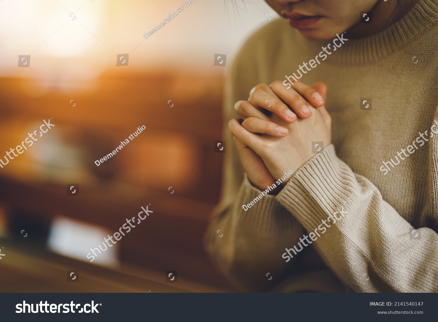 Christian life crisis prayer to god. Women Pray for god blessing to wishing have a better life. Hands praying to god with the bible. believe in goodness. Holding hands in prayer on a wooden table. #2141540147