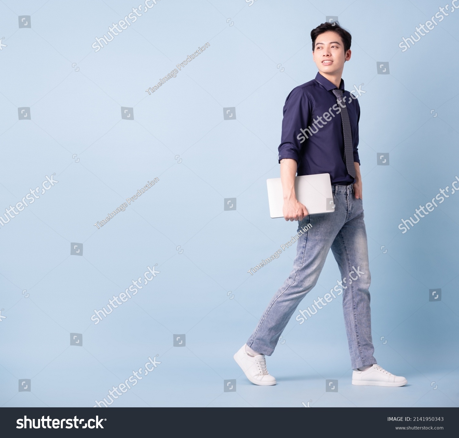 Full length image of young Asian businessman on blue background #2141950343
