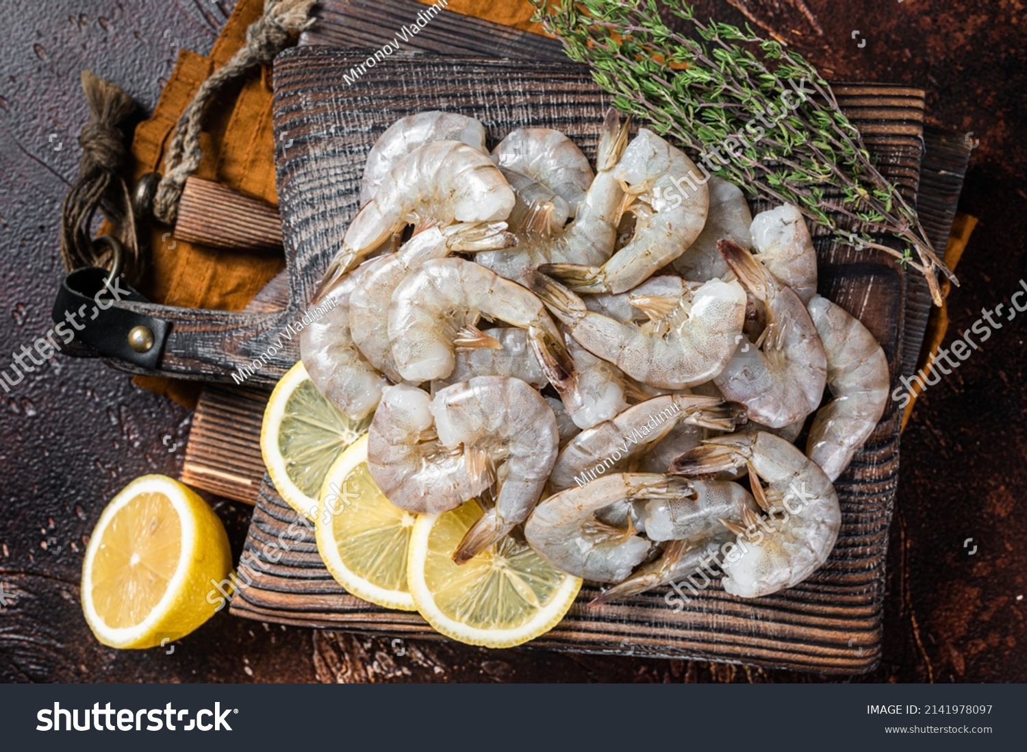 Raw tiger white shrimp prawn on board with herbs. Dark background. Top view. #2141978097