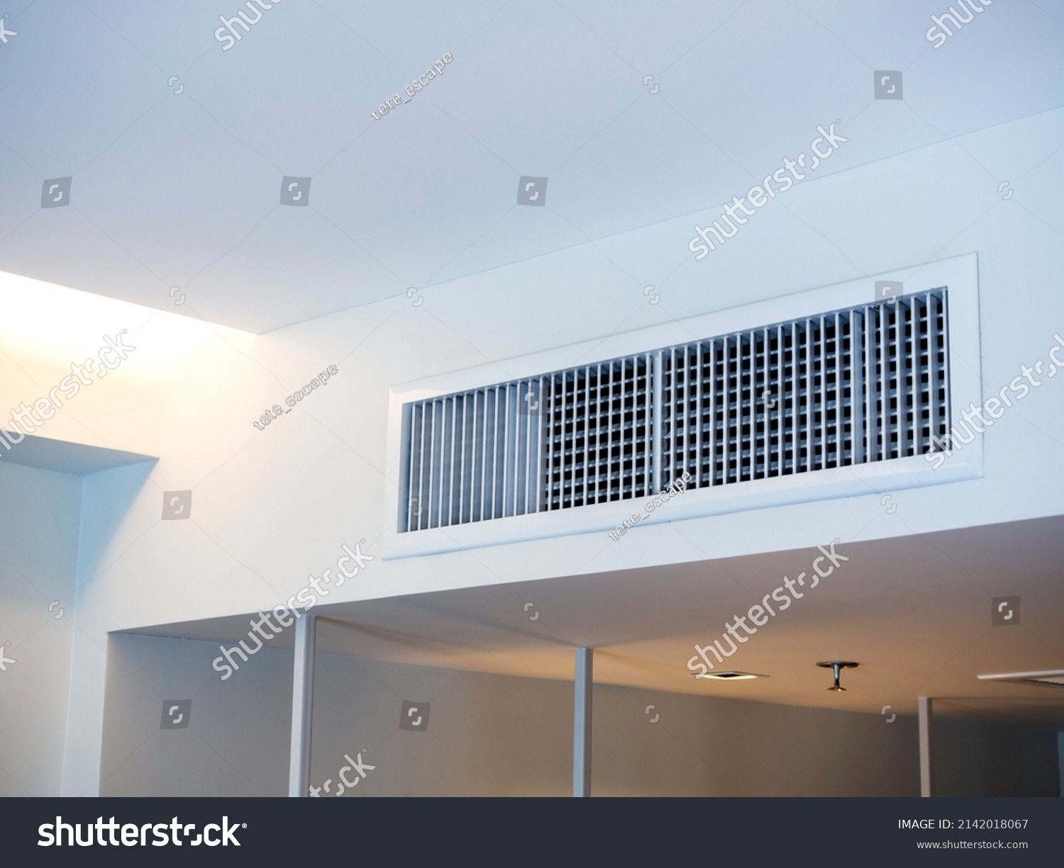 Air conditioning wall mounted ventilation system on ceiling in the white hotel room. Hotel room air ventilation grill on the wall. #2142018067