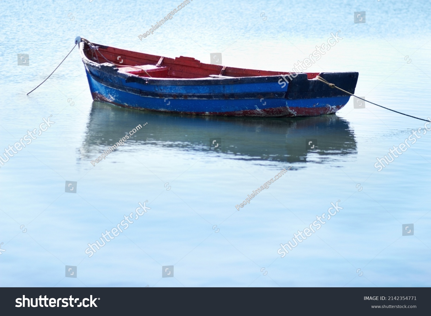 Not a breath of wind today. Shot of an empty fishing boat floating on calm waters. #2142354771