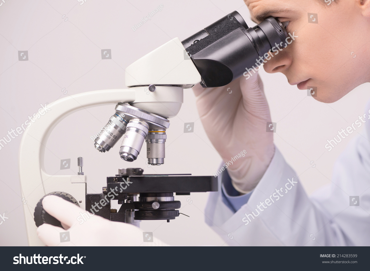 male scientist working in ab with microscope. clinician studying chemical elements in laboratory   #214283599