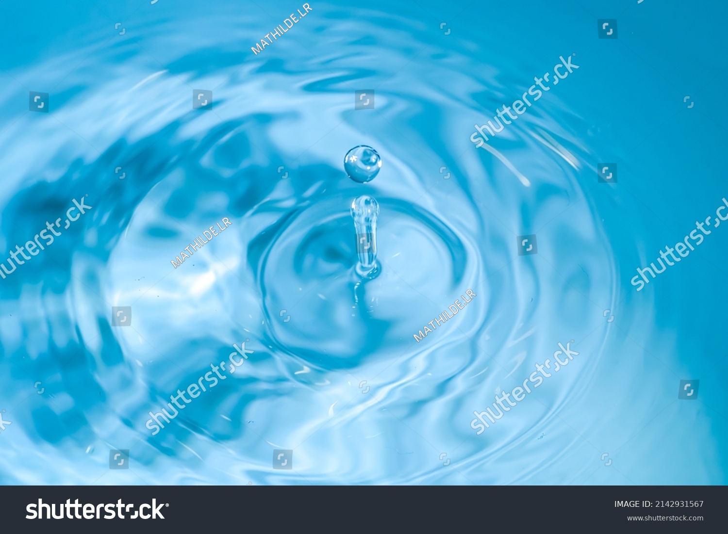 water drop splash blue colored. Round water drop. Water drop in glass. Drops, splashes, spray, abstract shapes out of the water #2142931567