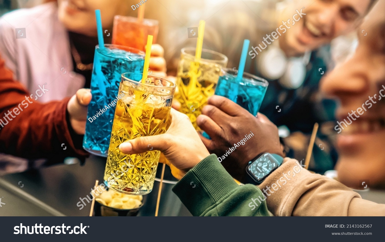Group of friends cheering drinks glasses together - Young people enjoying happy hour at cocktail open bar - Beverage lifestyle concept #2143162567