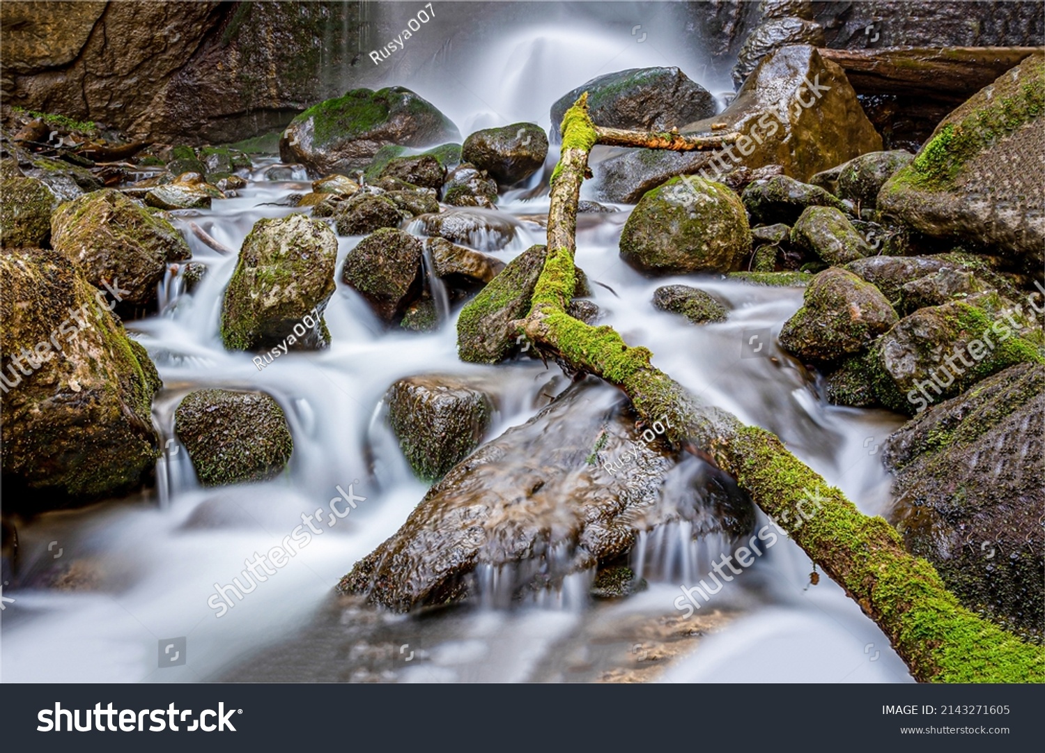 The waterfall flows over the stones. Waterfall stream. Mossy rocks of waterfall stream. Waterfall rocks #2143271605