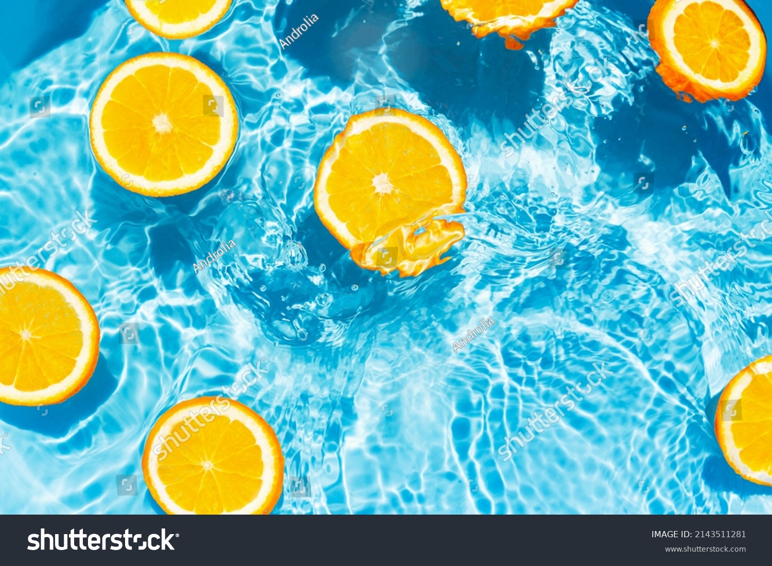 Creative summer composition made of sliced orange in transparent pool water. Refreshment concept. Healthy refreshing drink theme. Top view #2143511281